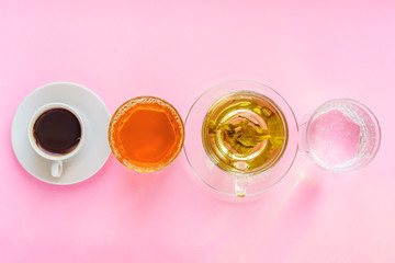 Top view of different beverages - drinking coffe, sparkling water, apple juice and green tea on...