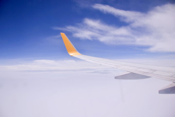 Obraz premium wing of an airplane flying above the clouds
