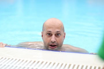 man in the pool with a surprise expression on his face