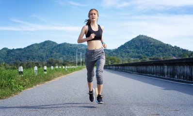 Asian woman jogging on the road in the morning