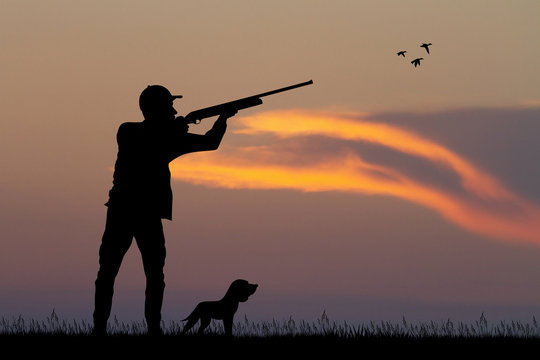 man hunting with the dog at sunset
