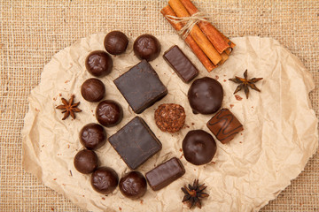 Chocolate candies rectangular and round shape put on pack paper in the form of a heart