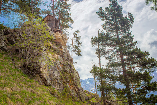 mountain hut stands on a rock surrounded by a coniferous forest in the mountains of Karachai-Cherkessia in Teberda