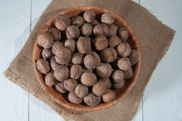Walnuts in bowl on burlap.