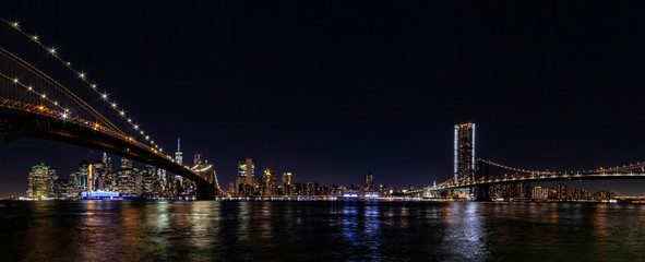 Fototapeta na wymiar Night wide angle panorama Manhattan panorama with Brooklyn and Manhattan bridges.