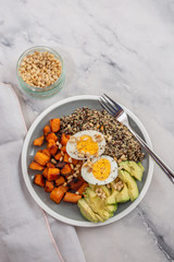 Quinoa salad in bowl with avocado