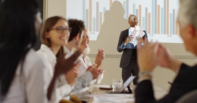 4K Enthusiastic extrovert businessman delivering fun presentation in a meeting