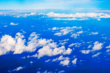 blue sky with cumulus clouds from an airplane window