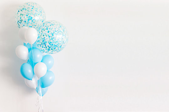 White And Blue Balloons On The White Wall Background.