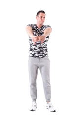 Athletic fit sport man stretching arms warming up and preparing for workout. Full body isolated on white background.