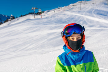 Fototapeta na wymiar Cute skier boy in a winter ski resort.