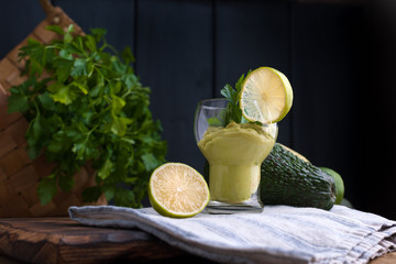 avocado smoothie and lime in a glass. Food for health and beauty. Super food from vegetables and fruits. Wooden background, free space for text.