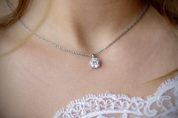 Morning gathering of the bride. Suspension on the neck. Beautiful neckline. Close-up.