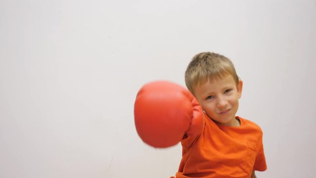 Portrait of child threatening with box gloves, boy throw off his gloves