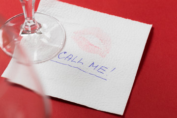 paper napkin with a kiss and wineglass on red background