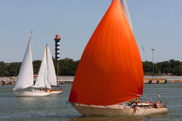 The romantic boat with scarlet sail in port.Yacht with red sails against the blue sky.