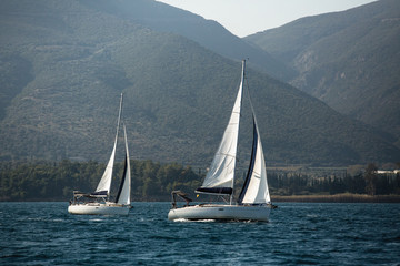 Fototapeta premium Yachts at sailing regatta in the wind through the waves at Sea.