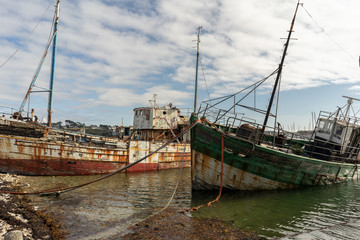 rotting ships with peeling paint and rotten structures on the Cemetery boat in Brittany, France