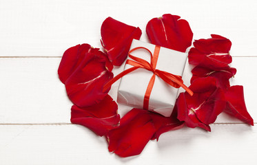 Gift box and rose petal on white background.