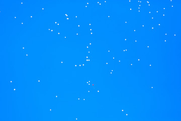 White balls flying in the blue sky