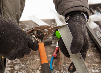 Obraz premium Worker mounts brown metal on the windows