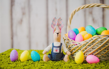 hare sitting on the grass with Easter eggs