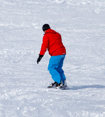 Fototapeta na wymiar A man snowboarding a mountain in the snow in winter