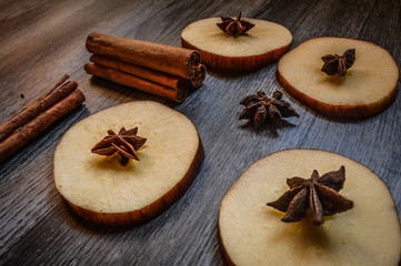 Star anise, cinnamon and apple on mader background.