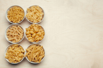 Different pasta types in bowls on the table.