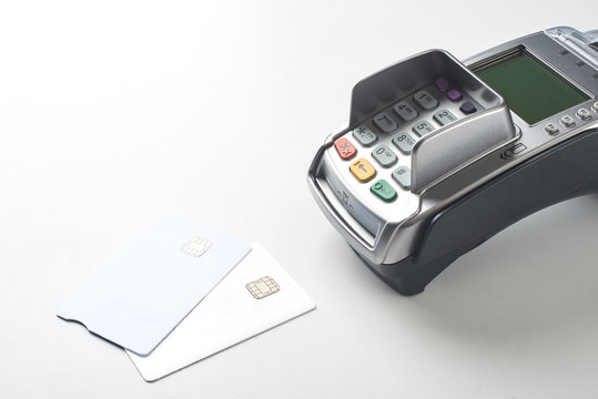 Credit Cards And Payment Terminal On White Table Background.