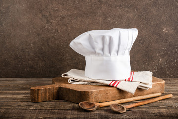 Chef's hat, antique cutting board and wooden spoons
