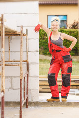 Woman in dungarees working on construction site