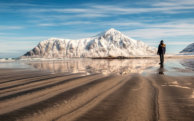 Man on sand furrows with snow mountain at Skagsanden