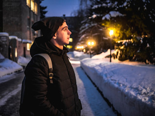 Fototapeta premium attractive man walk in city beetwen nightlights. winter season b