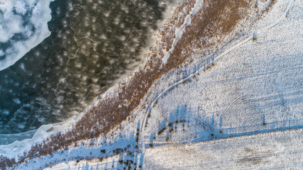 Aerial Drone Photograph of a Partly Frozen Lake Surrounded with Beautiful Winter Colors of the Fields and Forest