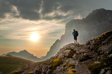 hiker enjoying a sunrise in the mountains