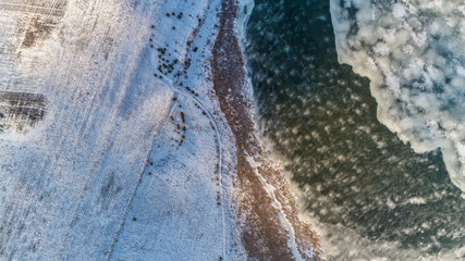 Aerial Drone Photograph of a Partly Frozen Lake Surrounded with Beautiful Winter Colors of the Fields and Forest