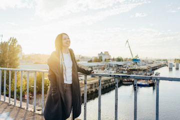 Happy smiling young woman in the city at the sunset