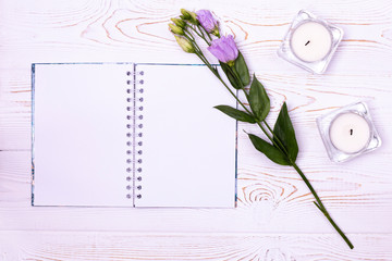 Stylish branding mockup to display your artworks.Blank notebook, flower, candles on a white background from above