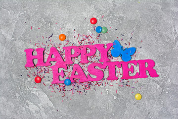 Pink text of happy easter with bright colorful dragee and sugar sprinkles