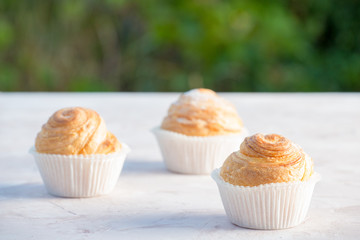 Fresh baked golden muffins on rustic wooden background shot in natural light