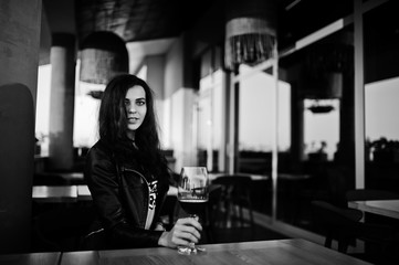 Young curly woman enjoying  her wine in a bar.
