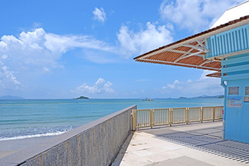 Beach, ocean, sky, blue house with wooden top and shadow