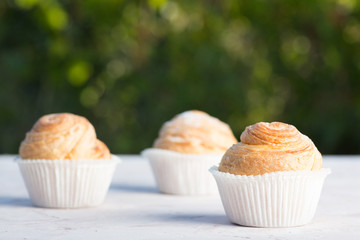 Fresh baked golden muffins on rustic wooden background shot in natural light