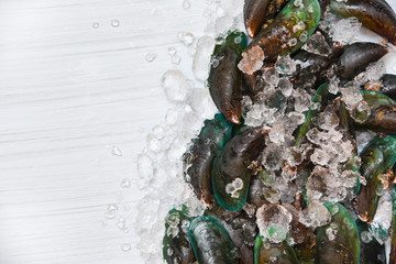 Seafood Mussel on ice background / Fresh raw green mussels ocean gourmet on ice and white wooden top view 