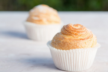 Fresh baked golden muffins on rustic wooden background shot in natural light