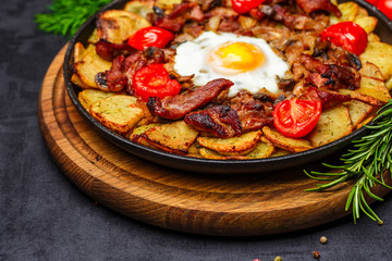 Baked potato wedges with cheese and herbs and tomato sauce on black background - homemade organic vegetable vegan vegetarian potato wedges snack food meal.