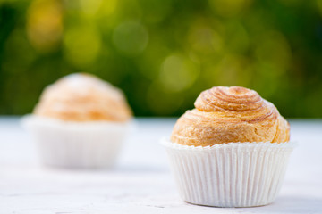 Fresh baked golden muffins on rustic wooden background shot in natural light