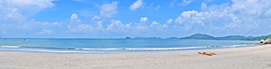 Fototapeta na wymiar Panorama of colourful kayak, beach, sea with wave, mountain, blue sky