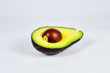 Fresh avocado cut in half with seed  isolated on white background.
